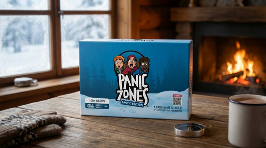 Panic Zones Arctic Edition card game box on rustic wooden table with fireplace and snowy window creating cozy winter atmosphere