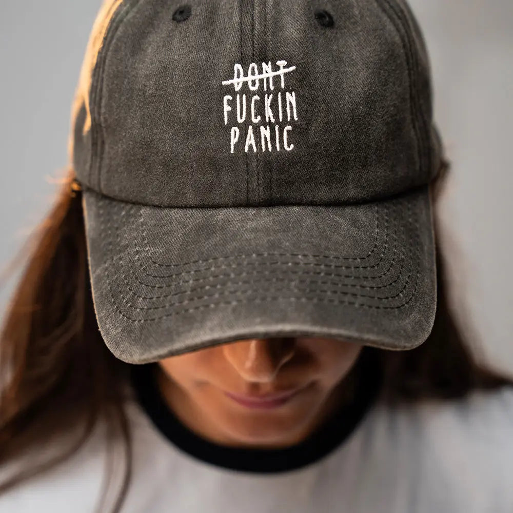 Person wearing a black Panic Zones Don't F**** Panic Cap — official Panic Zones merch